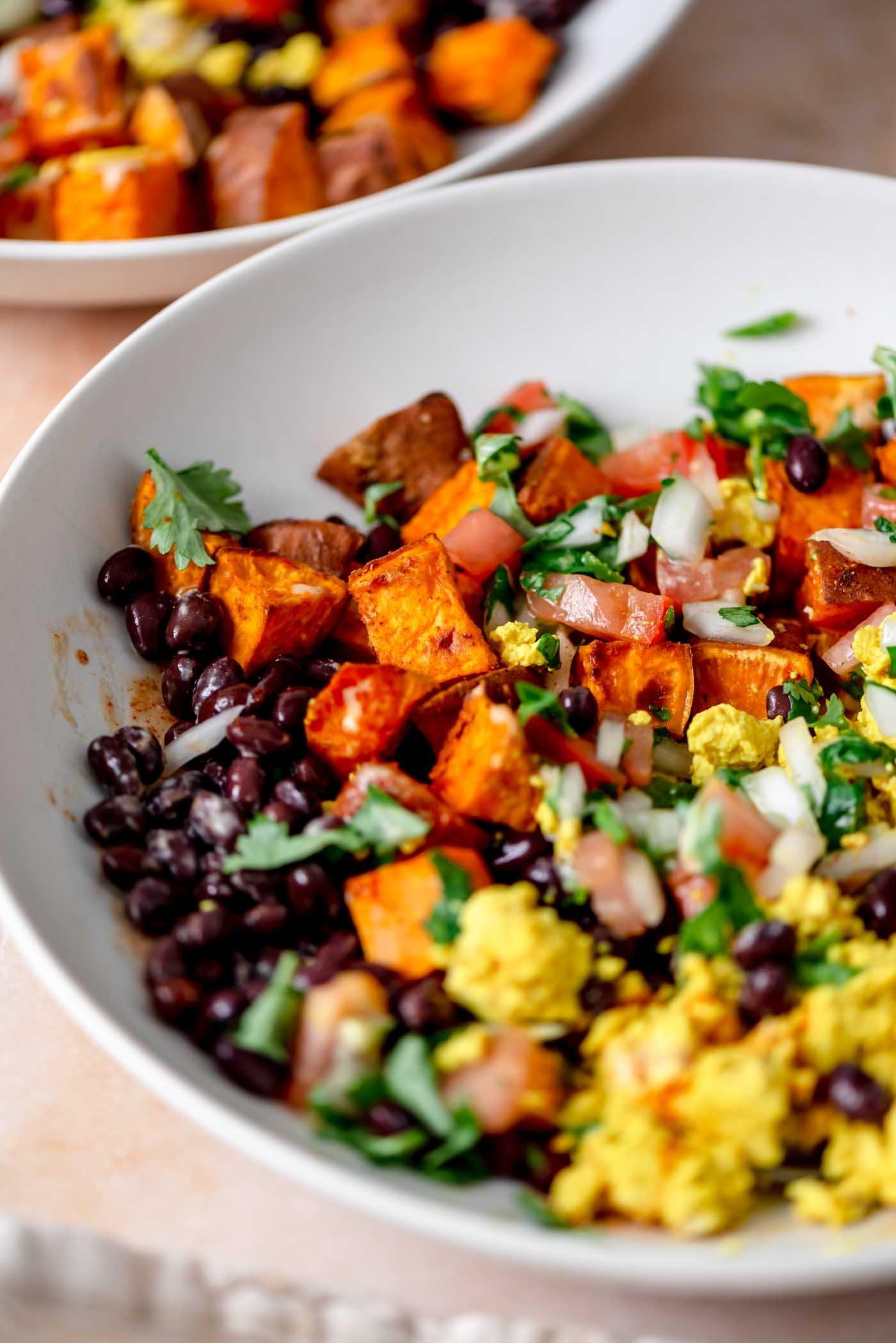 Ontbyt burrito bak met tofu roereier, swartbone, geroosterde patats en salsa alles saamgemeng.