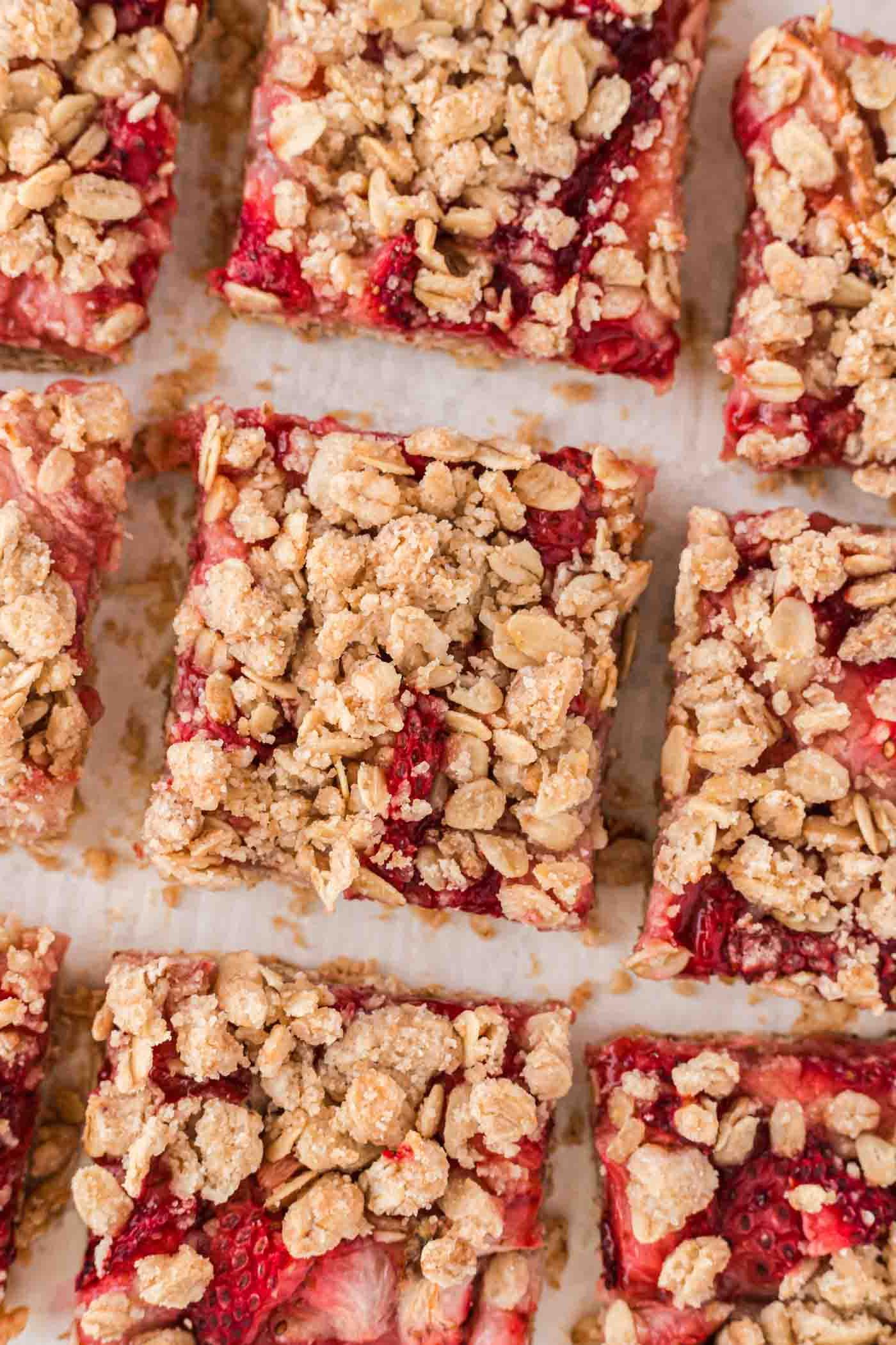 Vegan Aarbei Krummel Repies 2 ’n Bo-aansig van ’n aantal aarbei-hawermoutstafies met ’n hawermoutkrummeltopplaag.