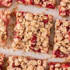 Vegan Aarbei Krummel Repies 11 ’n Bo-aansig van ’n aantal aarbei-hawermoutstafies met ’n hawermoutkrummeltopplaag.