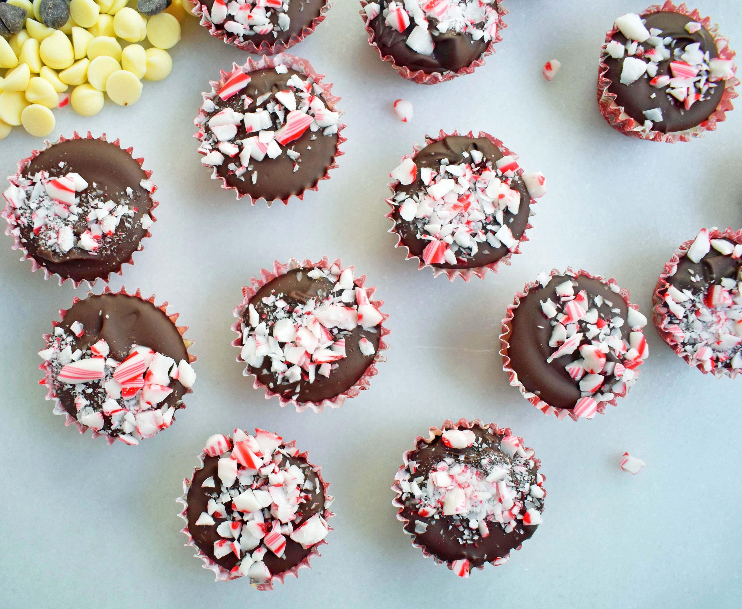 Κυπελλάκια Ζύμης Μπισκότου Peppermint Bark από το Modern Honey. Ζύμη μπισκότου με κομματάκια σοκολάτας χωρίς αυγά, στρωμένη με λευκή σοκολάτα και ημίγλυκη σοκολάτα, και γαρνιρισμένη με τριμμένα ζαχαρωτά μπαστούνια.