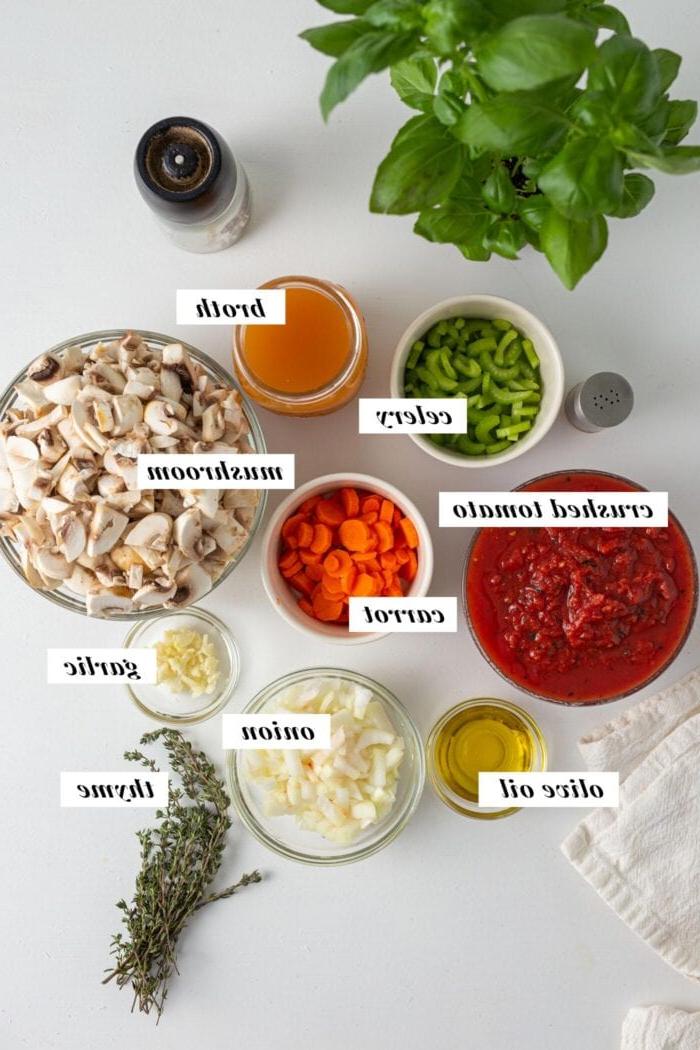 Visuele voorstelling van al die bestanddele wat benodig word vir die maak van 'n vegan sampioen bolognese sous. Elke bestanddeel is met teks-oorlegging geëtiketteer.