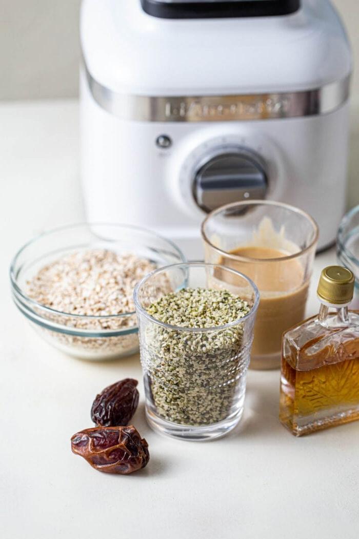 Vegan Tahini Hennepsaad Stafies 3 Hemp seeds, tahini, coconut, dates and maple syrup sitting on a counter top.