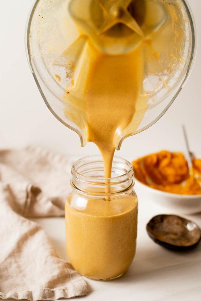 Grondboontjiebotter Pampoen Smoothy 4 Blender wat 'n pampoen smoothie in 'n glasfles skink.