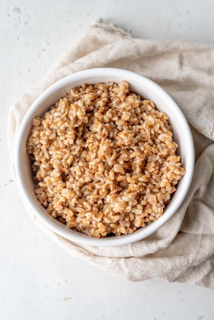 Gaar farro in 'n bak wat op 'n afdroogdoek rus.