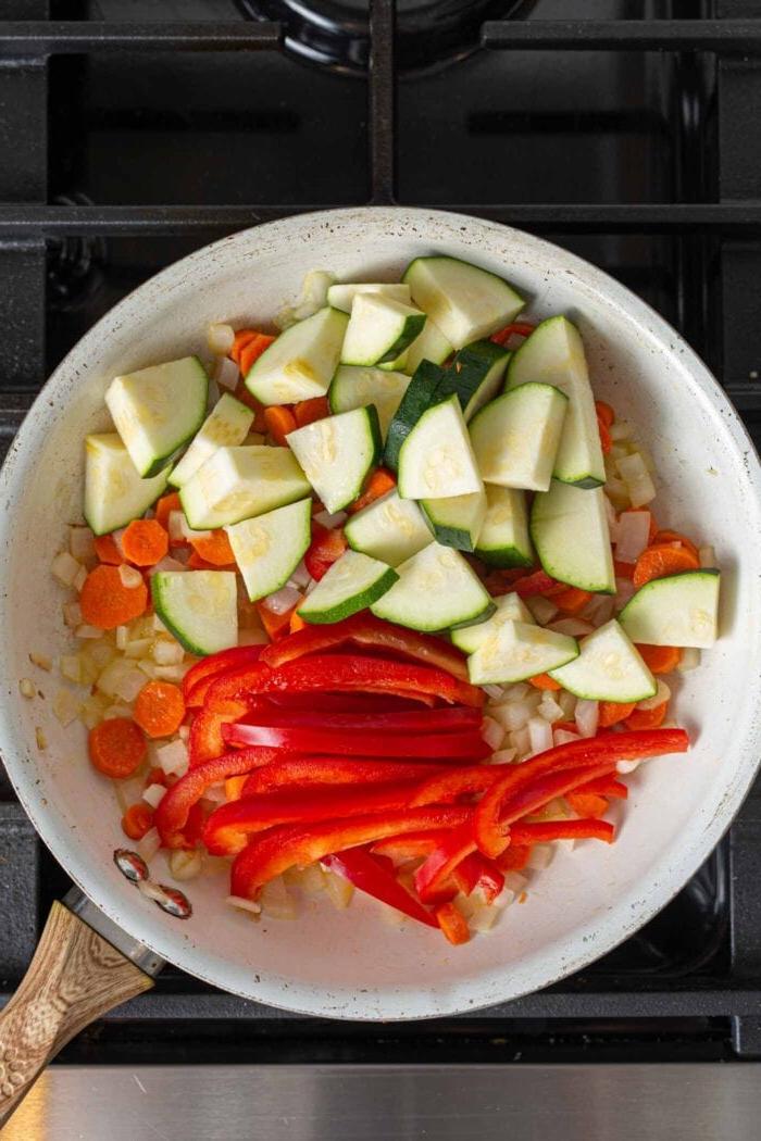 Vegans Panang Kerrie met Tofu 5 Gesnyde murgpampoentjies en dun gesnyde soetrissies in 'n pan met wortel, ui en knoffel.