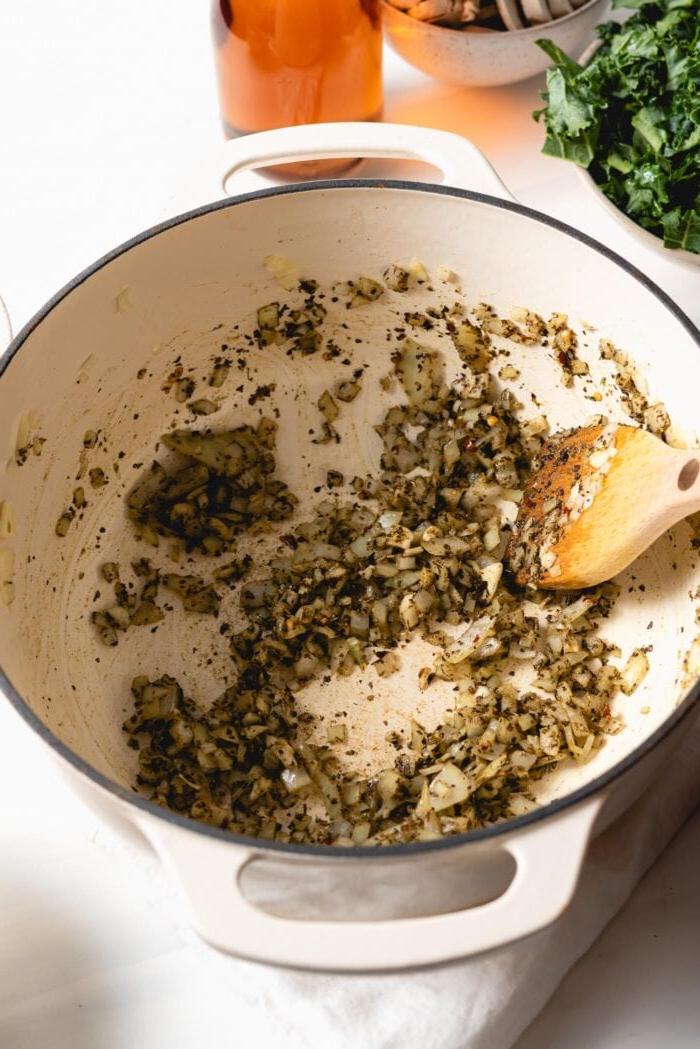 Vegan Een-pot Pasta 5 Chopped onions, garlic and dried herbs cooking in a large pot.
