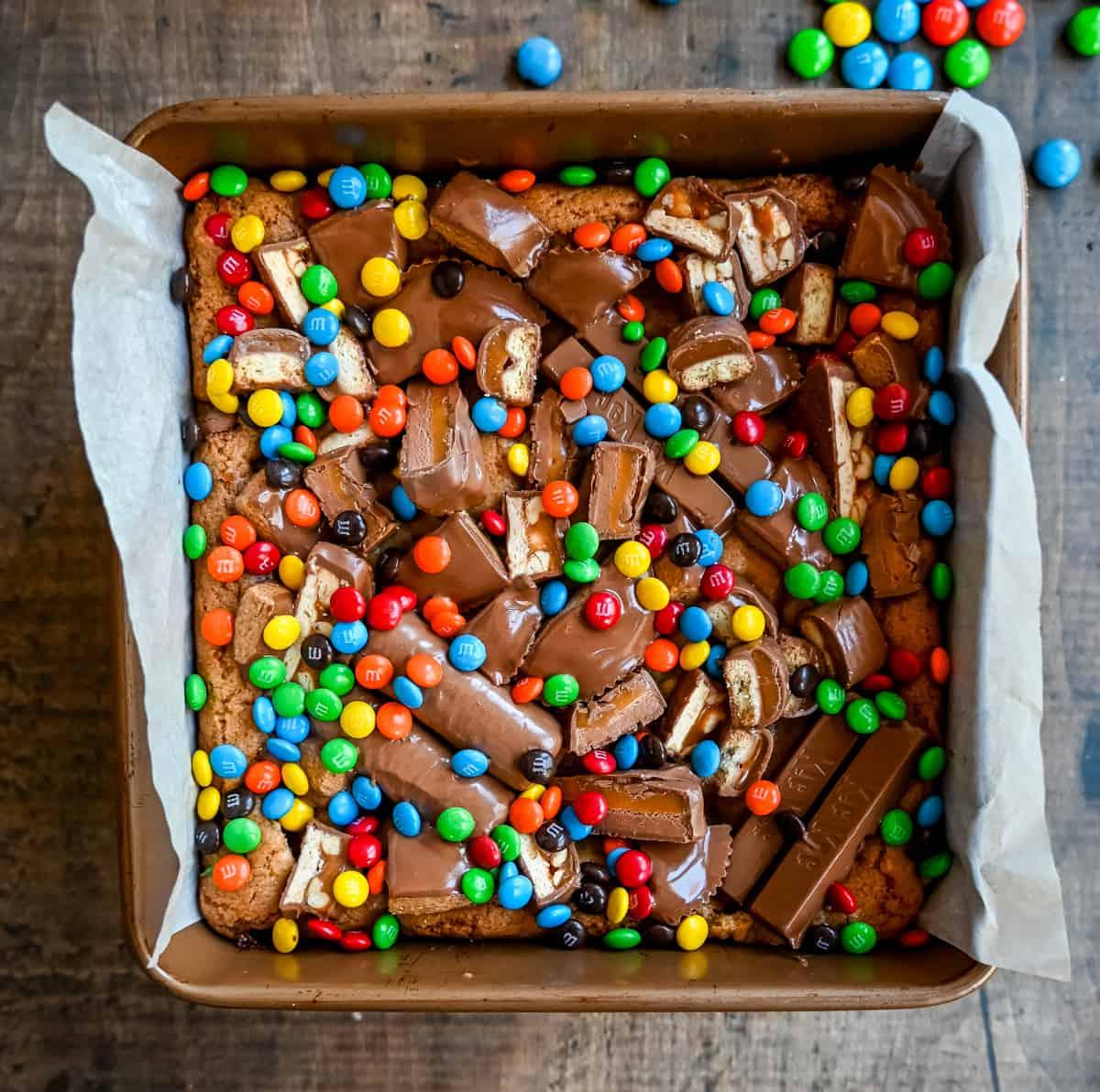 Candy Bar Μπάρες Μπισκότου 6 Μια απίστευτα μαλακή και ζουμερή μπάρα μπισκότου, γεμάτη με ποικιλία από σοκολάτες. Το τέλειο γλυκό blondie για να φτιάξετε με τις σοκολάτες του Halloween.