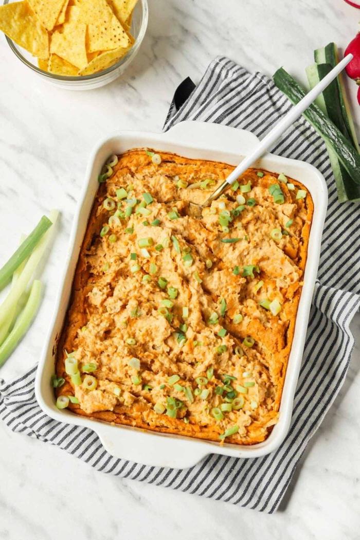 Vegan Buffels Dip 6 Gebakte buffel hoender dip bedek met groen uie in 'n bakplaat.