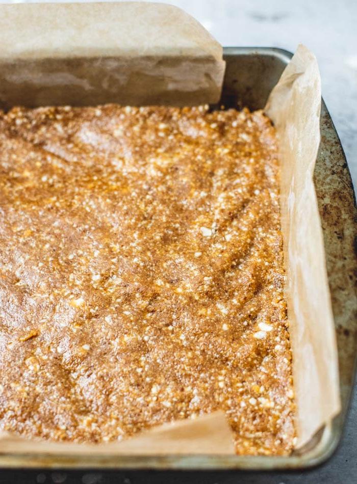 Kasjoe Tahini Stafies 6 Oorsig van die tekstuur van veganiese geen-bak rou tahini-kasjoepneut stafies, wat die digte, klam basis en die krakerige sjokolade-bolaag beklemtoon.