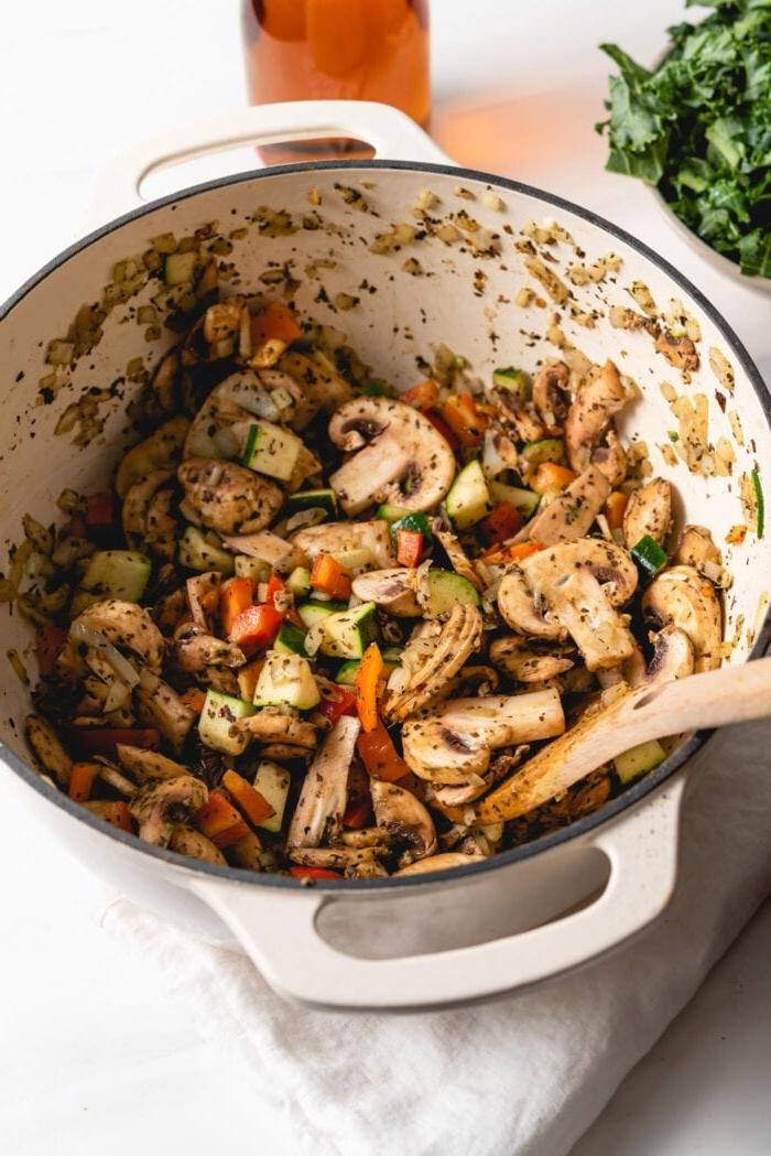 Vegan Een-pot Pasta 6 Chopped mushrooms, bell peppers and zucchini cooking in a large pot.