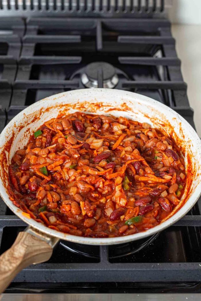 Veganes Chili Kaas Tjips 6 Gaar chili in 'n pan op 'n gasstoof.