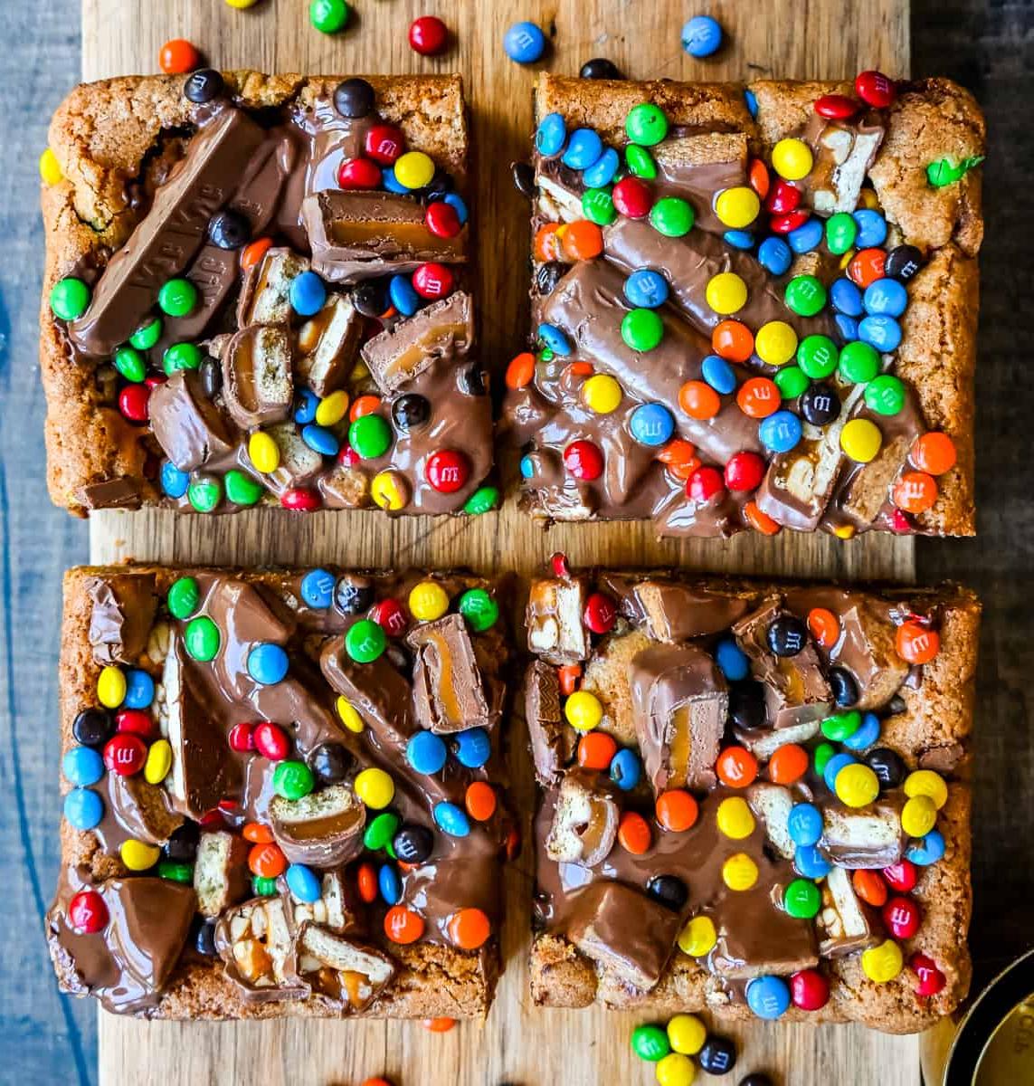 Candy Bar Μπάρες Μπισκότου 7 Μια απίστευτα μαλακή και ζουμερή μπάρα μπισκότου, γεμάτη με ποικιλία από σοκολάτες. Το τέλειο γλυκό blondie για να φτιάξετε με τις σοκολάτες του Halloween.