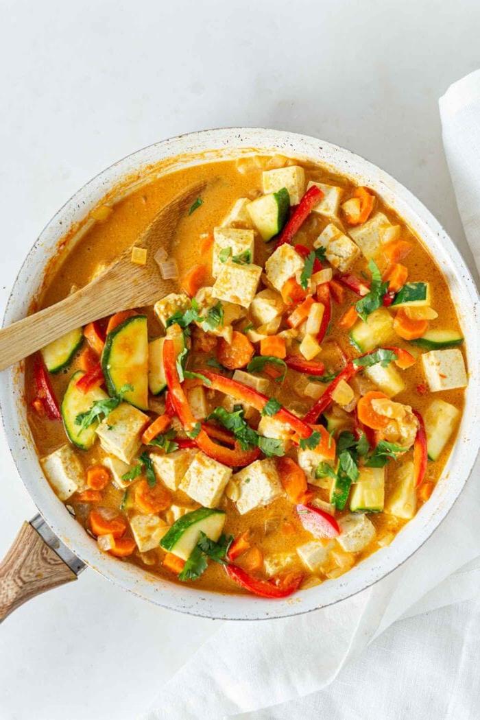 Vegans Panang Kerrie met Tofu 7 Dik en romerige groentekerrie met tofu in 'n pan met 'n houtlepel.
