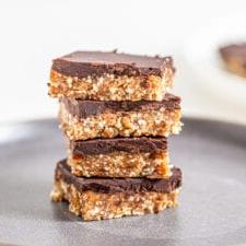 Ongebakte Kasjoeneut Koekiedeeg Stafies 8 Stapel van 4 sjokoladebedekte kasjoeneutstafies op 'n bord.