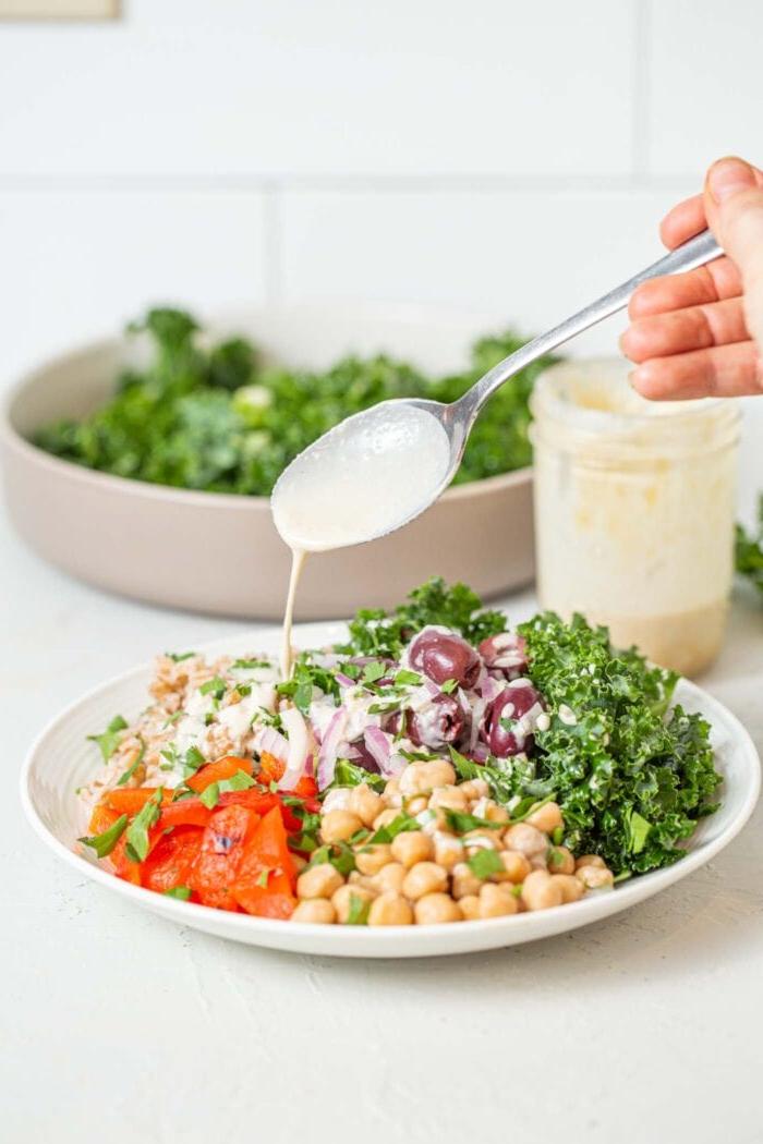 Drup tahini oor 'n bak farro, boerenkool, geroosterde rooipepers en kekerertjies.