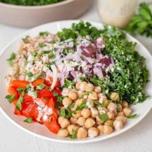 Bak met farro, geroosterde rooipeper, uie, olywe, kekerertjies, boerenkool en slaaisous.
