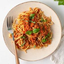 Bovenaansig van 'n bord spaghetti en bolognese sous.