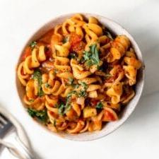 Vegan Een-pot Pasta 10 Overhead view of a bowl of rotini pasta with tomato sauce and vegetables.
