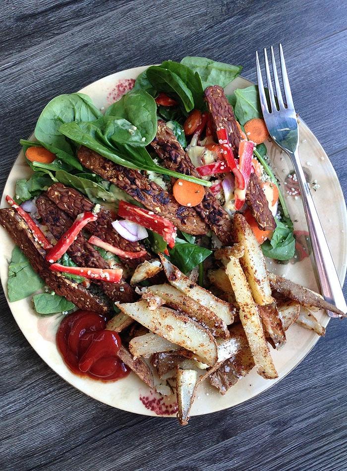 Vegan Makros Eetplanne 9 ’n Groot bord groen slaai met tempeh en gebakte aartappelwiggies – ’n voedsame en gebalanseerde vegan maaltyd.