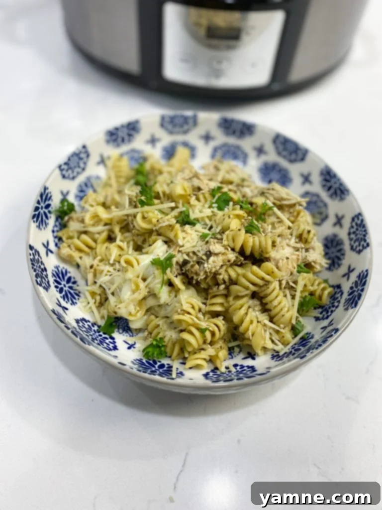 Ingredients for Slow Cooker Pesto Chicken Pasta laid out on a wooden board