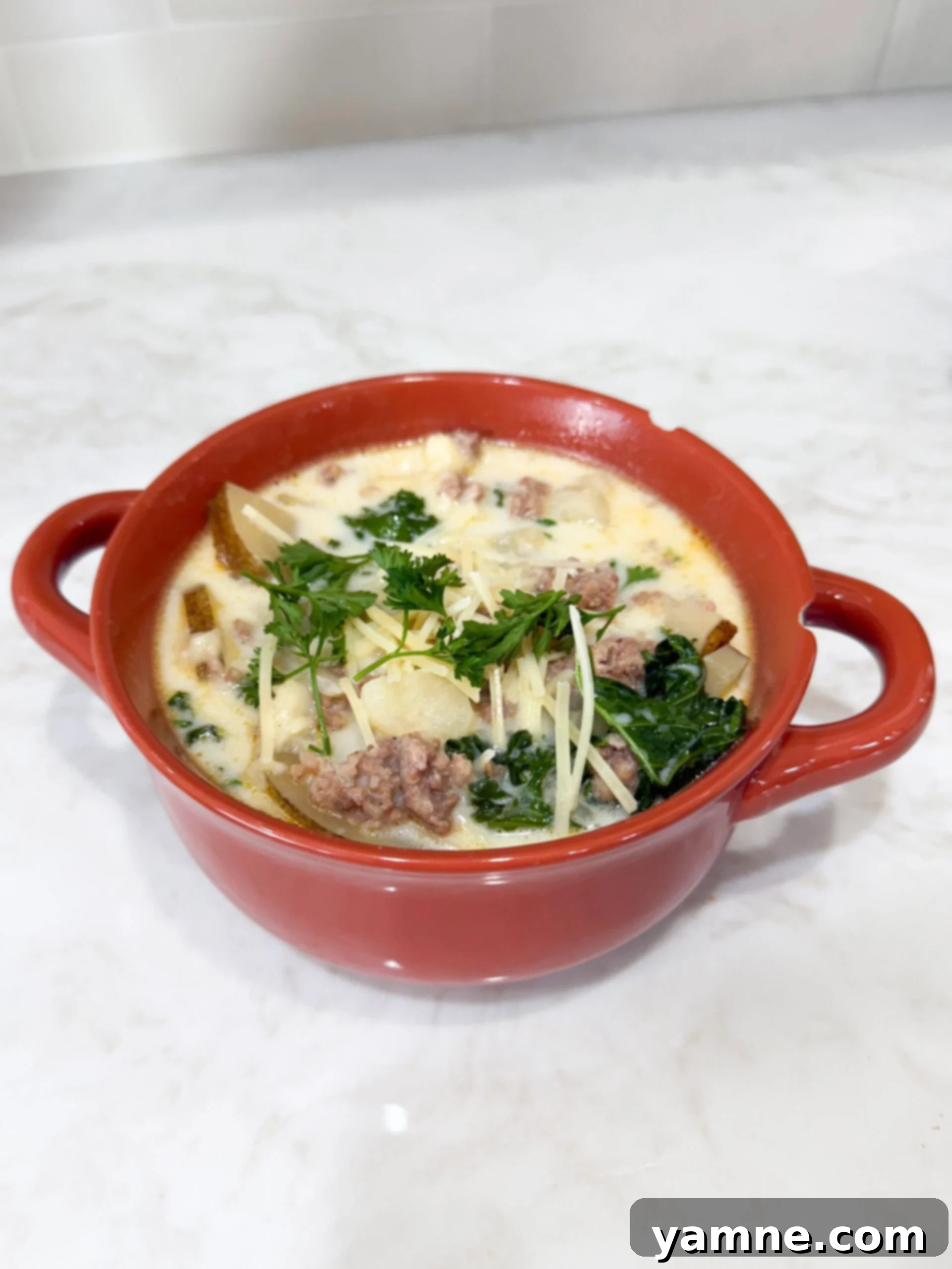 Bowl of creamy zuppa toscana soup with sausage, potatoes, and kale