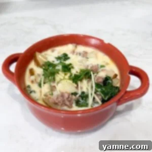 Bowl of zuppa toscana soup topped with Parmesan
