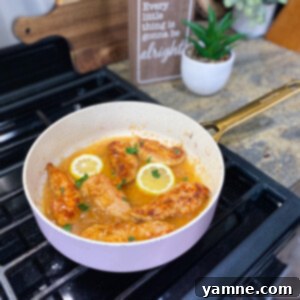 Honey Lemon Chicken Tenders in a skillet with lemon slices