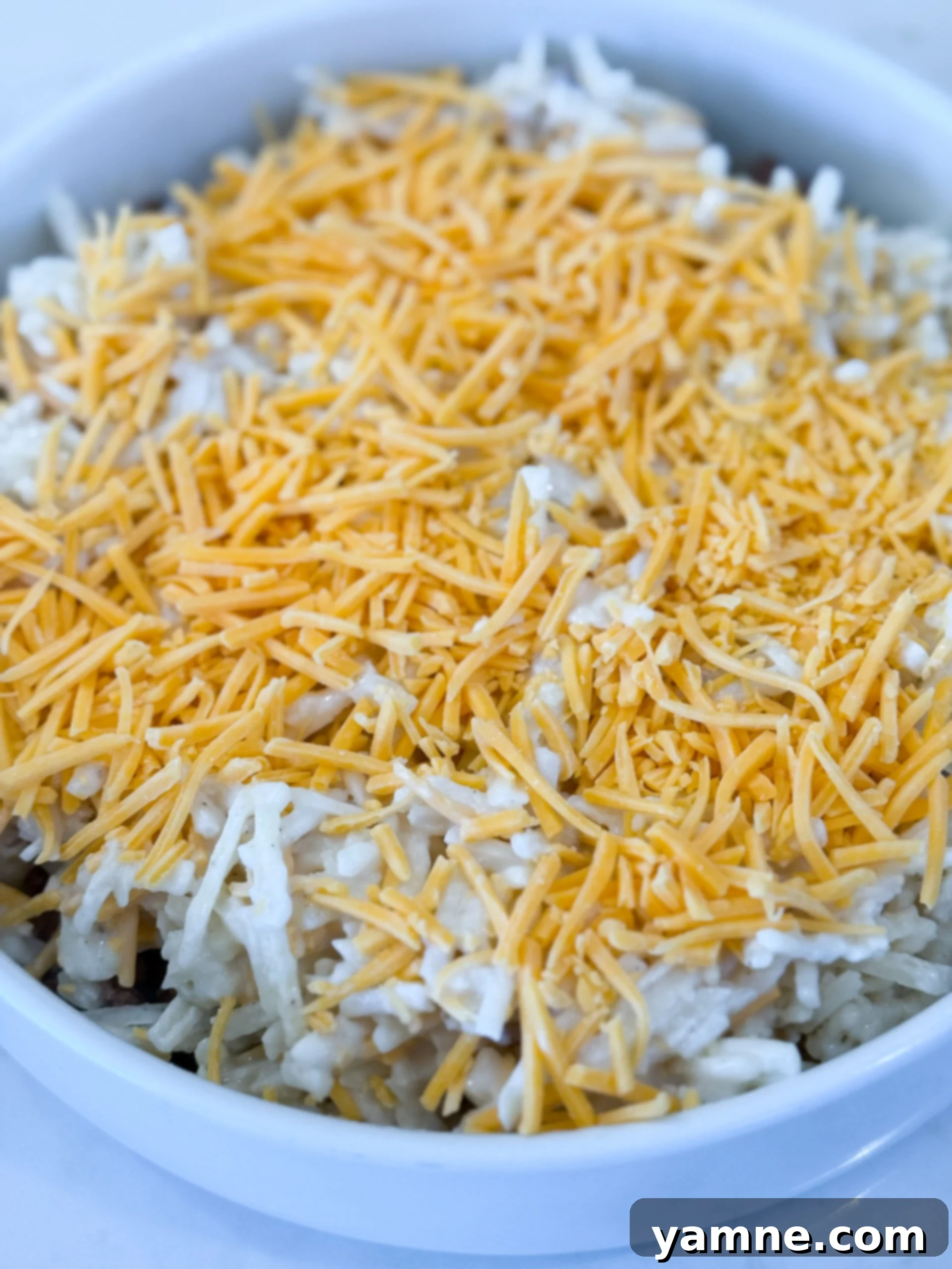 Layering beef and hashbrown mixture in baking dish