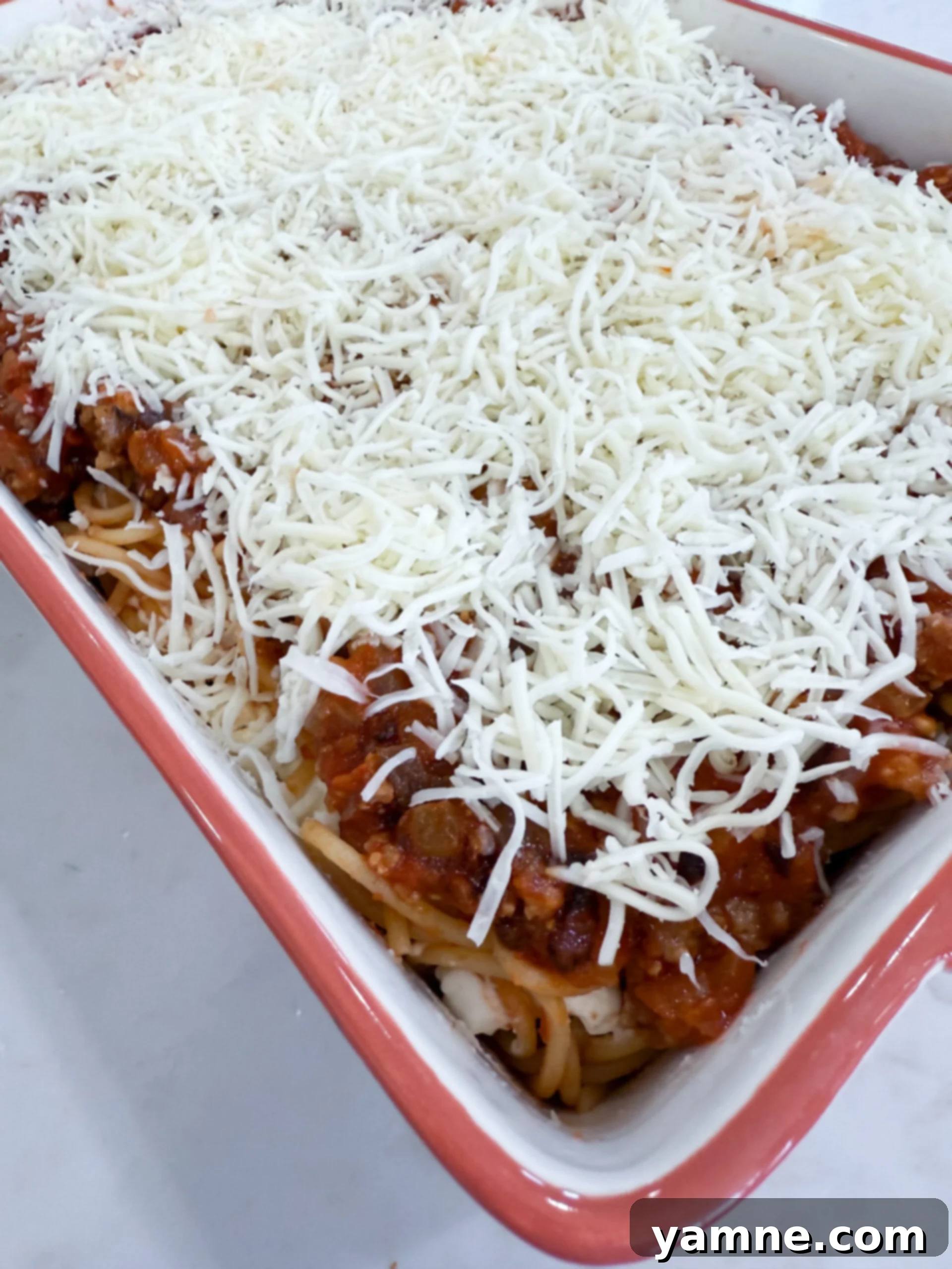 Shredded mozzarella sprinkled on top of the casserole before baking.