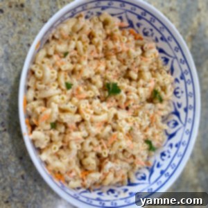 Creamy and delicious Hawaiian Mac Salad in a white bowl, garnished with fresh herbs, ready to be served as a classic island side dish.