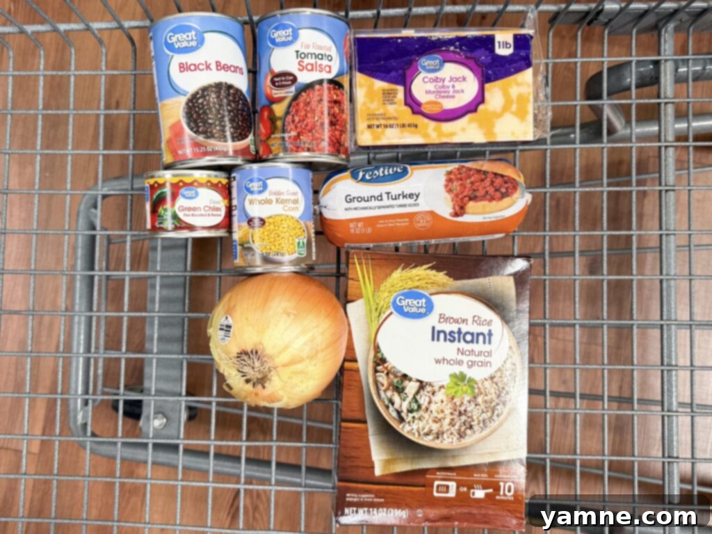 A spread of fresh ingredients for Mexican beef and rice one-pot meal including ground meat, diced onion, instant rice, spices, salsa, beans, corn, cherry tomatoes, and shredded cheese.