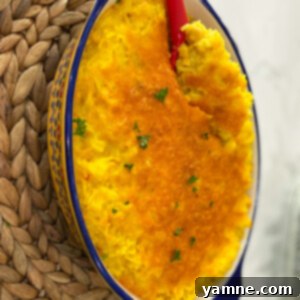 A golden yellow rice casserole with melted cheese on top.