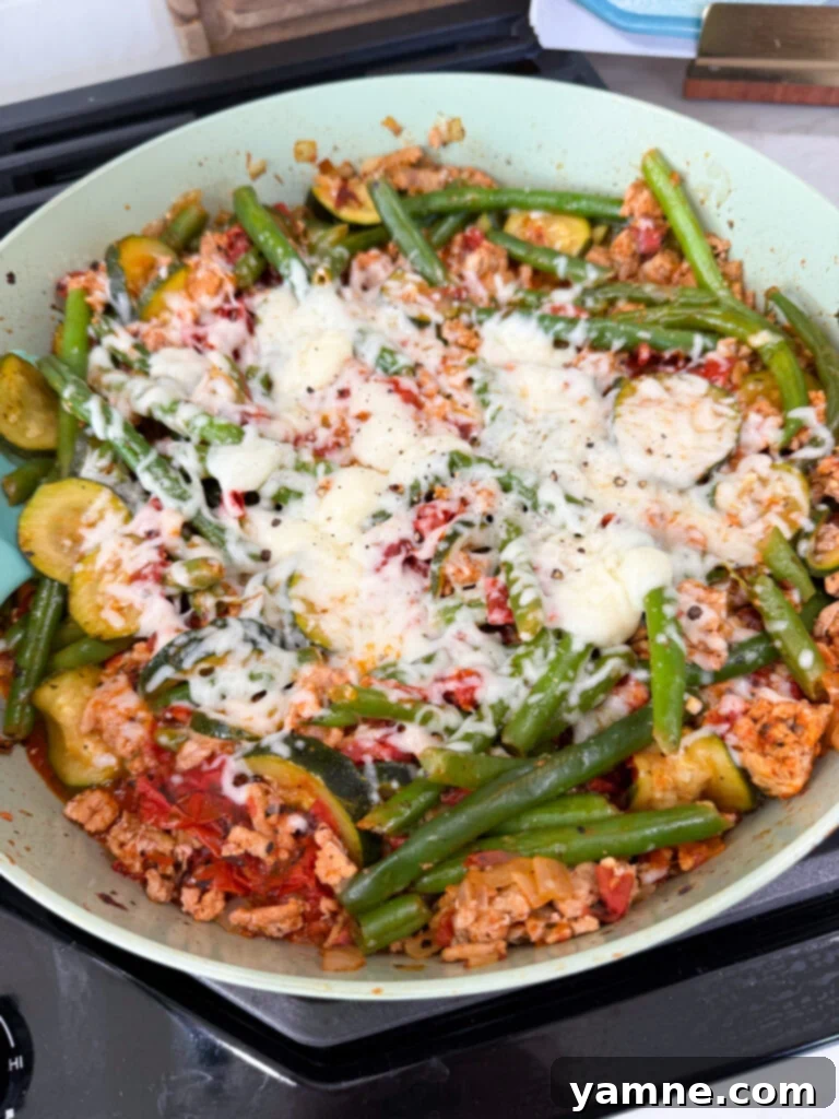 Healthy Turkey and Veggie Skillet 2 Close-up of melted parmesan cheese topping a turkey vegetable skillet
