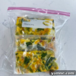 Sheet Pan Omelet Bake 2 A beautifully baked sheet pan breakfast omelette topped with cheese, bacon, and fresh greens, ready to be sliced.