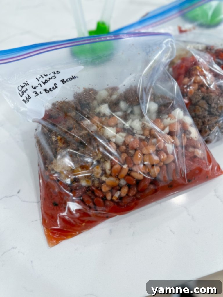 A labeled gallon-sized freezer bag filled with slow cooker chili ingredients, ready for the freezer.