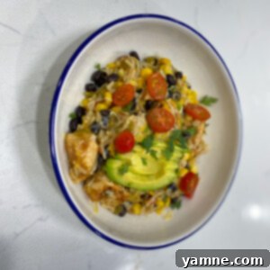A vibrant Loaded Rice Burrito Bowl featuring seasoned chicken, Spanish rice, black beans, corn, and fresh toppings.