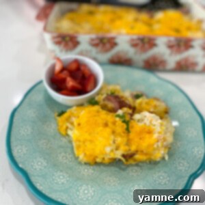 Country Sausage and Hashbrown Casserole with melted cheese and herbs on top.