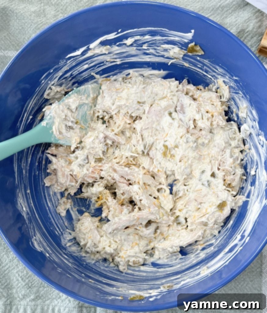 Ultimate Green Chile Chicken Enchiladas 4 Mixing the green chili chicken enchilada filling in a bowl.