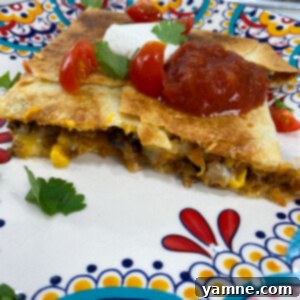 Loaded Taco Quesadillas 3 Close-up of a cut taco quesadilla showing the ground beef, cheese, and tortilla chips filling.