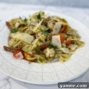A top-down shot of the finished One-Pot Sun-Dried Tomato Chicken Pasta, garnished with fresh basil.