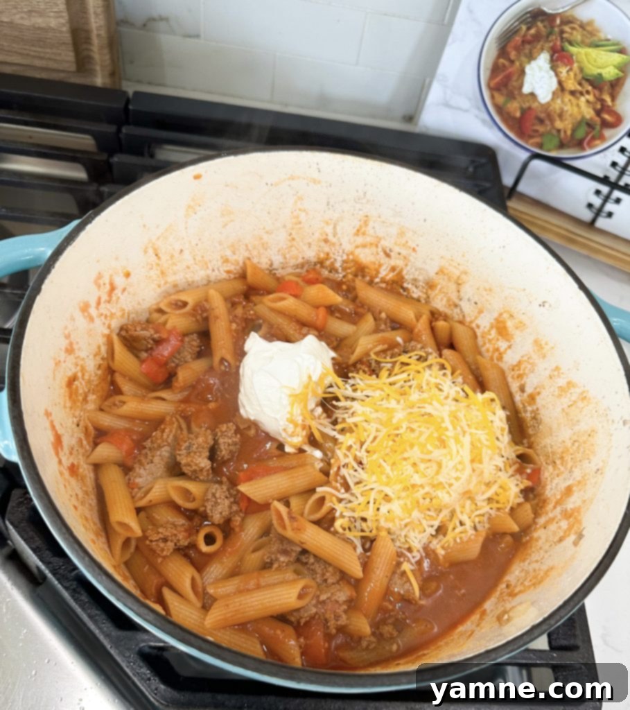 Penne pasta simmering in a rich tomato and turkey sauce in a one-pot meal.