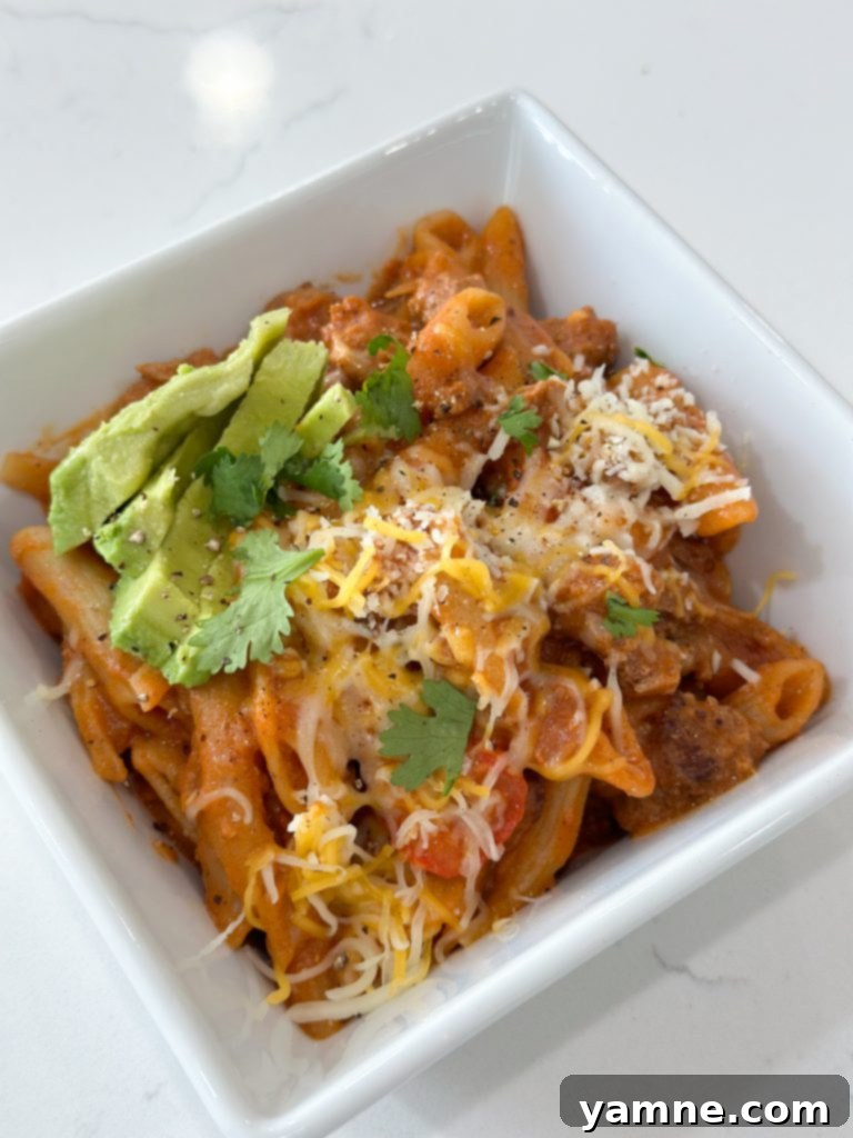 Close-up of the finished one-pot ground turkey pasta with avocado and cilantro.