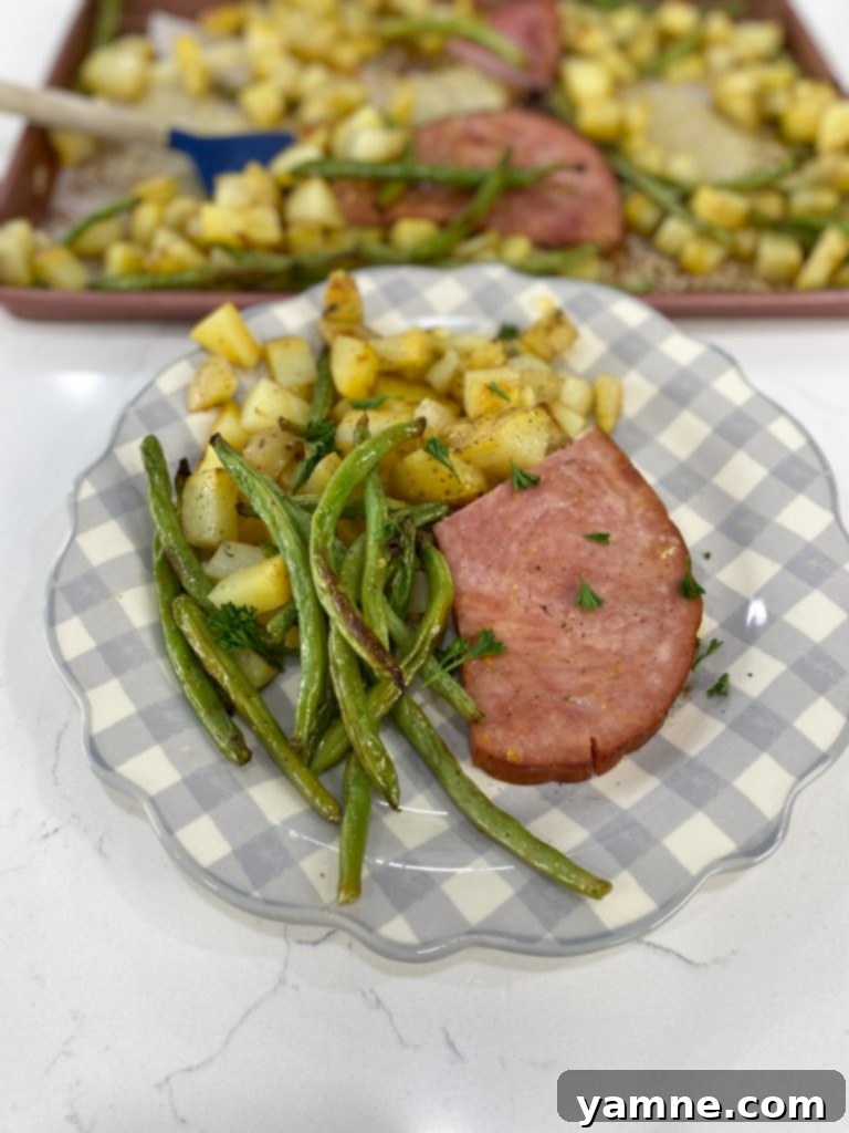 One-Pan Honey Mustard Ham, Green Beans, and Potatoes 3 A sheet pan with diced golden potatoes and trimmed green beans, seasoned and ready for the oven for the first stage of roasting.