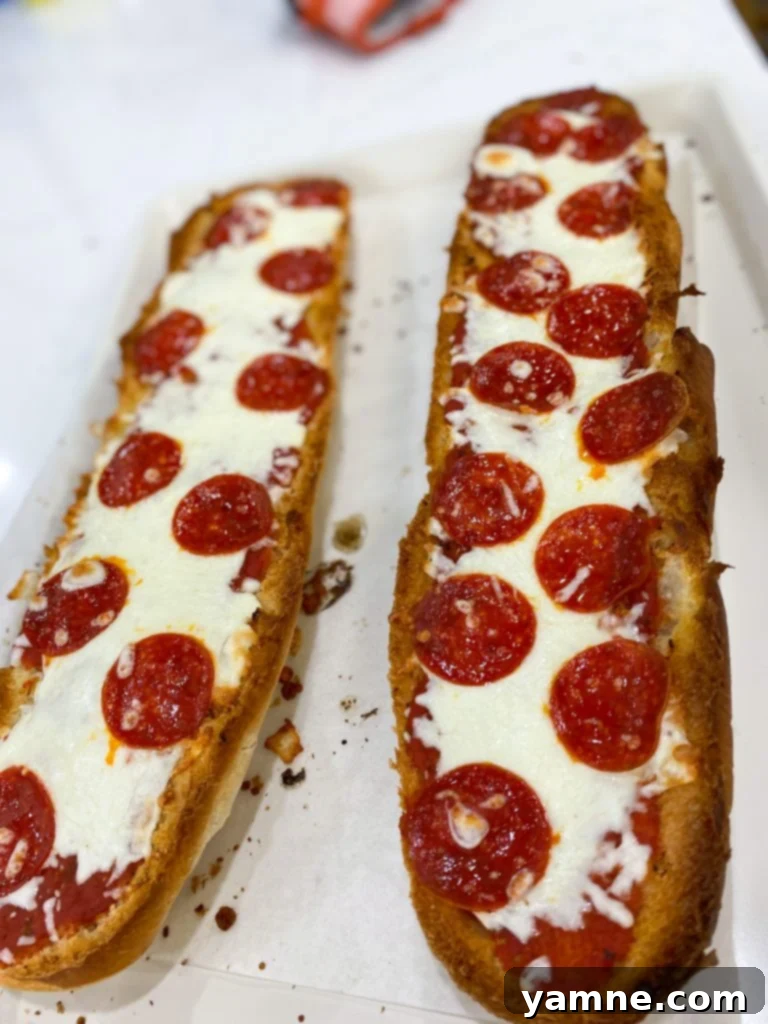 Crispy French Bread Pizzas 3 Unbaked French Bread Pizzas with sauce, cheese, and pepperoni on a baking sheet