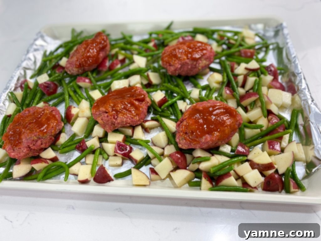 One-Pan Cheesy Stuffed Meatloaf and Roasted Veggies 3 Close-up of the ingredients for Mozzarella Stuffed Meatloaf, including ground beef, spices, and mozzarella cubes.