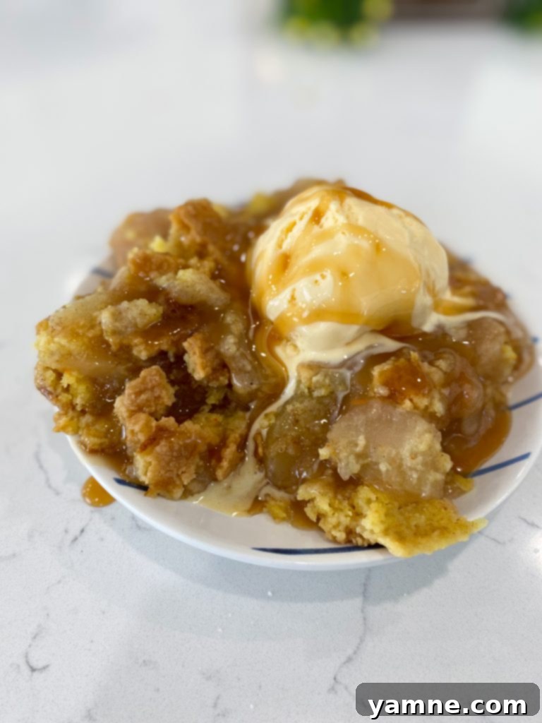 Close-up of the uncooked Apple Dump Cake ingredients layered in a baking dish before baking, showing the dry cake mix and butter slices on top of apple filling.