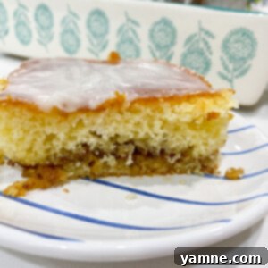 Honey Bun Cake with a cinnamon swirl and glaze on a white plate.