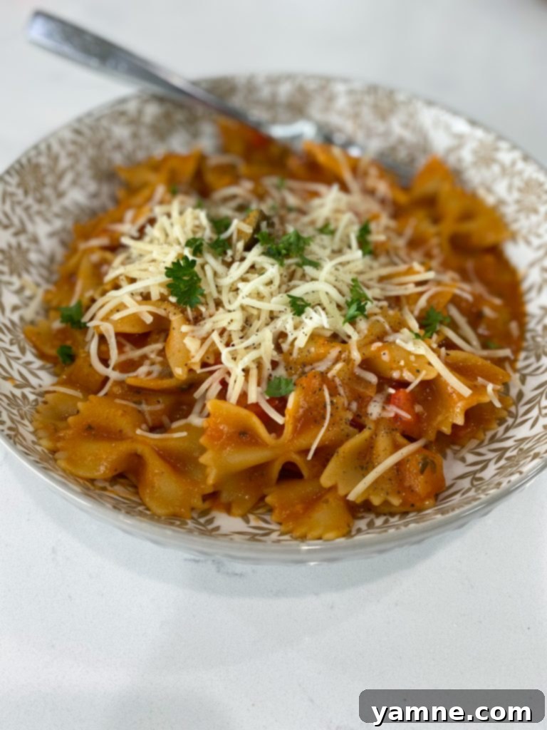 One-Pan Tuscan Vegetable Pasta 4 A large Dutch oven on a stovetop, filled with sautéing diced bell peppers, onions, and garlic for an Italian vegetable pasta.
