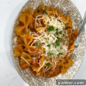 One-Pan Tuscan Vegetable Pasta 5 Close-up of a bowl of Italian Vegetable Pasta, garnished with fresh herbs and cheese.