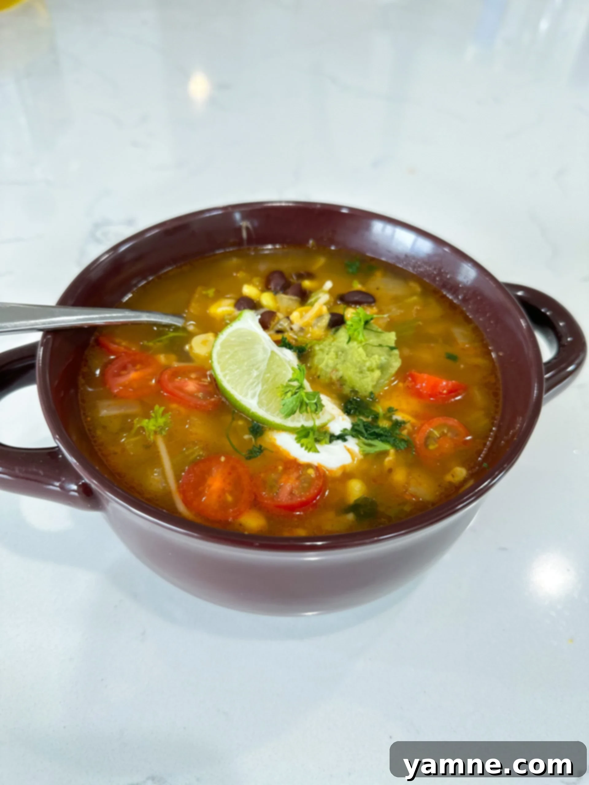 Bowl of Spanish rice soup with beans, corn, and tomatoes in tomato broth